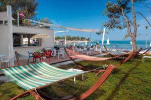 un grupo de hamacas sentadas en una terraza cerca del océano en Apartments Stella Plava Laguna en Umag