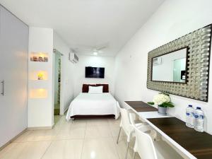 um quarto com uma cama, uma mesa e um espelho em Aparta estudios nuevos Mubarak em Barranquilla