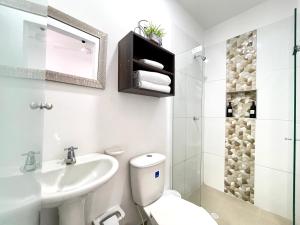 biała łazienka z toaletą i umywalką w obiekcie Aparta estudios nuevos Mubarak w mieście Barranquilla