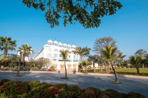 a large white building with palm trees in front of it at Radisson Blu Udaipur Palace Resort & Spa in Udaipur