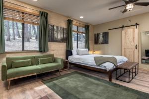 ein Schlafzimmer mit einem Bett und einem grünen Sofa in der Unterkunft Little House in the Big Woods in Forest Ranch
