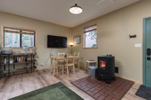 a living room with a wood stove and a table at Little House in the Big Woods in Forest Ranch