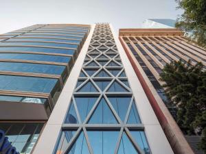 un edificio alto con ventanas de cristal en el lateral. en Novotel Mexico City World Trade Center en Ciudad de México