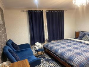 una camera con letto e sedia blu di Spacious loft converted bedroom with toilet only, Separate guest shower on ground floor plus free parking a Hanworth