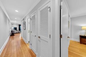 a hallway with white doors and wood floors at 1303 Pelican Watch Villa in Seabrook Island