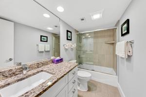 a bathroom with a sink and a toilet and a mirror at 1303 Pelican Watch Villa in Seabrook Island +26 photos