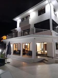 a large white house at night with a patio at Maison L'Horizon in De Quincey Village