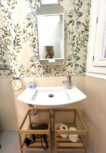 a bathroom with a white sink and a mirror at El 1 de Amador de los Rios in Toledo