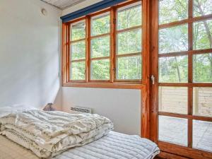 Bett in einem Zimmer mit offenem Fenster in der Unterkunft Three-Bedroom Holiday home in Rønne 4 in Rønne