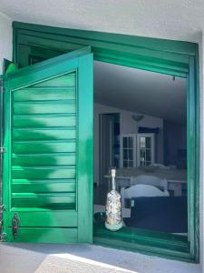 una puerta verde con una botella delante de un espejo en LA TERRAZZA SUL MARE, en Porto Empedocle