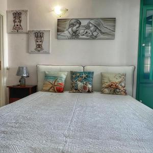1 dormitorio con 1 cama con 3 cuadros en la pared en LA TERRAZZA SUL MARE, en Porto Empedocle