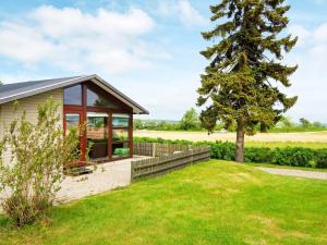 a small house with a tree in the yard at 5 person holiday home in Juelsminde in Sønderby