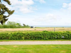 a walkway in a field with the ocean in the background at 5 person holiday home in Juelsminde in Sønderby