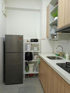 a kitchen with a stainless steel refrigerator and a sink at Studio 14 Vacation with Pool in Shah Alam City in Shah Alam