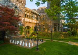 a large brick building with a chess board in the yard at Castle Hotel & Spa in Tarrytown
