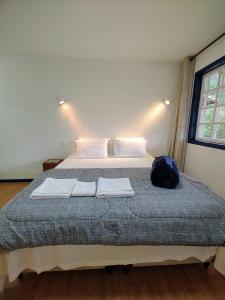 a bedroom with a bed with two towels on it at Recanto Serra do Trovão in Ouro Preto