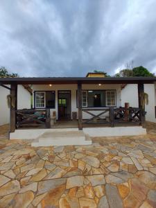 a house with a stone patio in front of it at Recanto Serra do Trovão in Ouro Preto