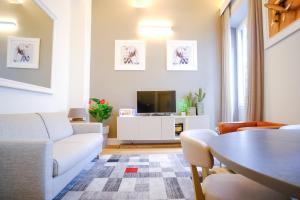 a living room with a couch and a tv at Dolcevita Boutique Apartment in Florence
