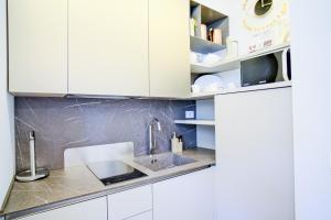a kitchen with white cabinets and a sink at Dolcevita Boutique Apartment in Florence