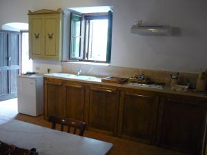 cocina con armarios de madera, fregadero y ventana en Casa nella Fortezza, en Pitigliano