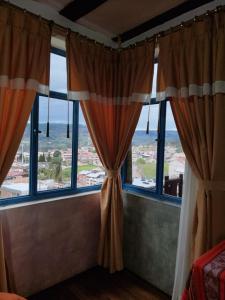 een kamer met ramen met uitzicht op de oceaan bij Hotel Achik Wasi in Saraguro