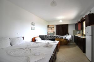 a bedroom with a bed and a kitchen with a couch at Vila Bilali in Ksamil