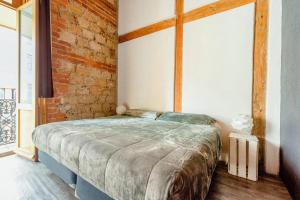 a bedroom with a large bed with a brick wall at Del Lago Lofts Downtown in Mexico City