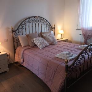 een slaapkamer met een groot bed en een roze deken bij LA CASA DI SOPRA in Martano