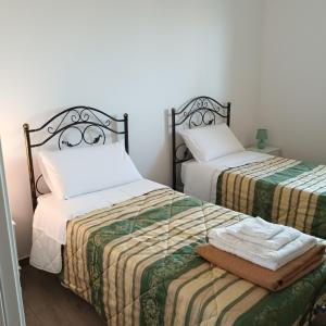 twee bedden in een kamer met twee handdoeken bij LA CASA DI SOPRA in Martano