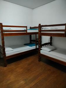 サンパウロにあるFriends forever hostelのウッドフロアの客室で、木製の二段ベッド2台が備わります。