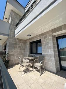 a patio with chairs and a table on a building at Perla apartmani in Petrovac na Moru