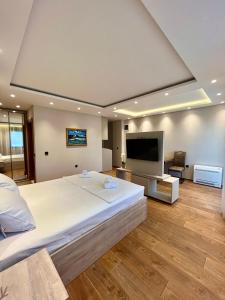 a large bedroom with a large bed and a flat screen tv at Perla apartmani in Petrovac na Moru