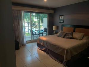 1 dormitorio con 1 cama y balcón con mesa en Condominio c/ alberca y vista a Marina Mazatlán, en Mazatlán