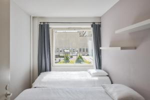 - une chambre avec 2 lits et une fenêtre dans l'établissement Norden Homes Peaceful & Central Apt. Free Parking, à Turku