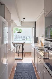 a white kitchen with a table and a window at Norden Homes Peaceful & Central Apt. Free Parking in Turku