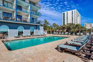 a swimming pool with lounge chairs and a building at Bluewater Resort 816 in Myrtle Beach