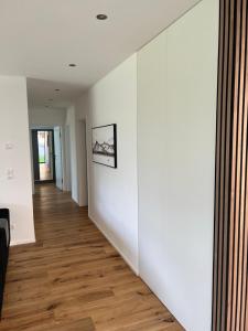 an empty hallway with white walls and wood floors at Haus Am Anger Dornbirn in Dornbirn