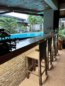 un bar avec des chaises et une piscine dans l'établissement Ariella Mangrove & Eco Resort by Hiverooms, à Bulalacaw