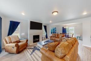 a living room with two couches and a fireplace at Pelican and the Raven in Rockaway Beach