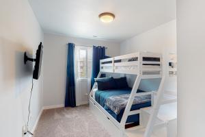a bedroom with a bunk bed and blue curtains at Pelican and the Raven in Rockaway Beach