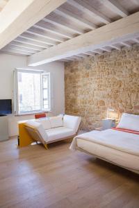 una camera con due letti e un muro di mattoni di La Bandita Townhouse a Pienza