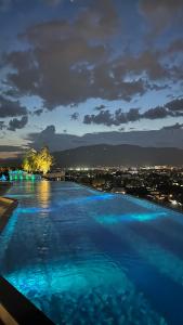 a swimming pool at night with a view of a city at Astra Sky River Chiang Mai in Chiang Mai