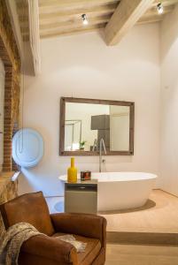 a bathroom with a tub and a mirror on the wall at La Bandita Townhouse in Pienza