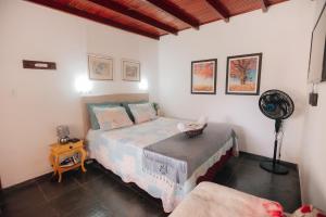 1 dormitorio con 1 cama y ventilador en Chalé das Carpas en Penedo
