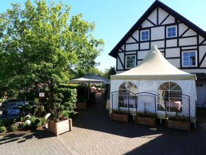 una tenda bianca di fronte a un edificio bianco e nero di Landgasthof Hoffmann GbR ad Arnsberg