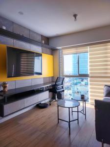 a living room with a tv and a couch and a table at Depa acogedor en el corazón de la ciudad in Lima