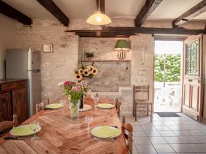 een keuken met een houten tafel met bloemen erop bij Maison Girou Haut in Montcabrier