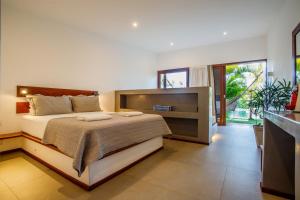um quarto com uma cama e uma grande janela em Portofino Pousada em São Miguel do Gostoso