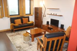 ein Wohnzimmer mit einem Sofa und einem Tisch in der Unterkunft Casa da Escola in Vouzela