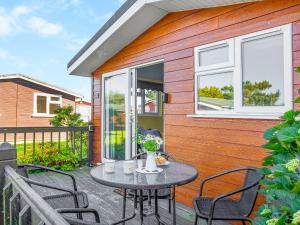 a patio with a table and chairs in front of a house at Skylarks in St Merryn